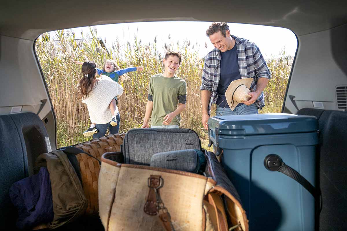 A happy family packing the car on vacation