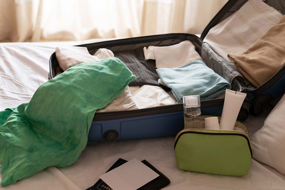 Half packed suitcase laying on a bed